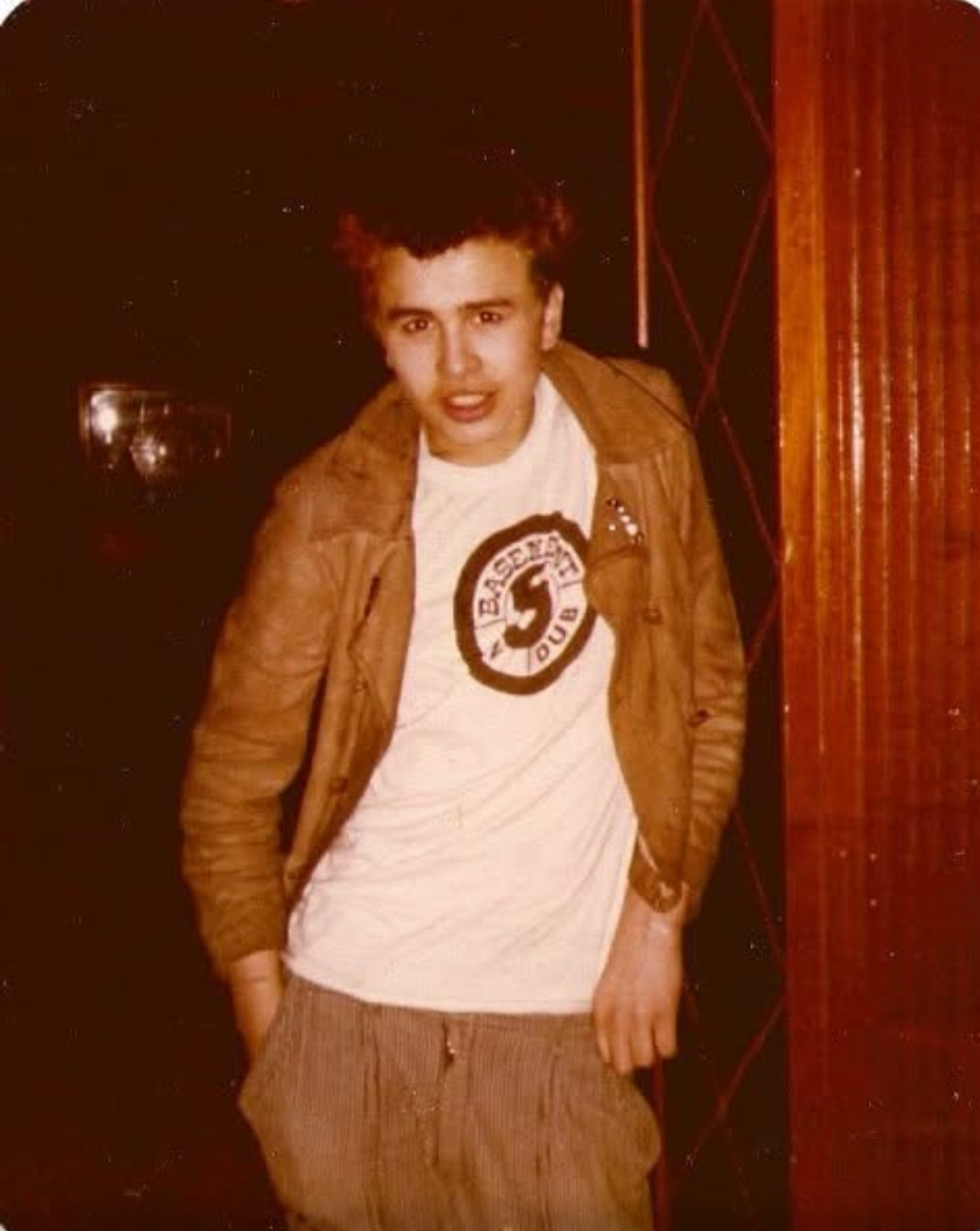 Young man in a suede jacket over a hand-printed Basement 5 dub t-shirt